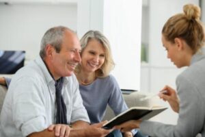 Couple smiles while looking at brochure about Blue Cross Blue Shield Massachusetts insurance coverage