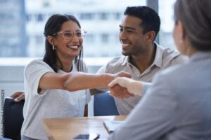 Woman shakes hand with person after she and husband sign on with United Healthcare insurance coverage