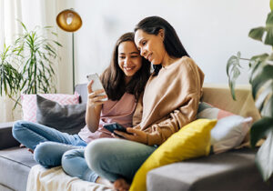 Mom and daughter on couch discuss teen mental illness signs
