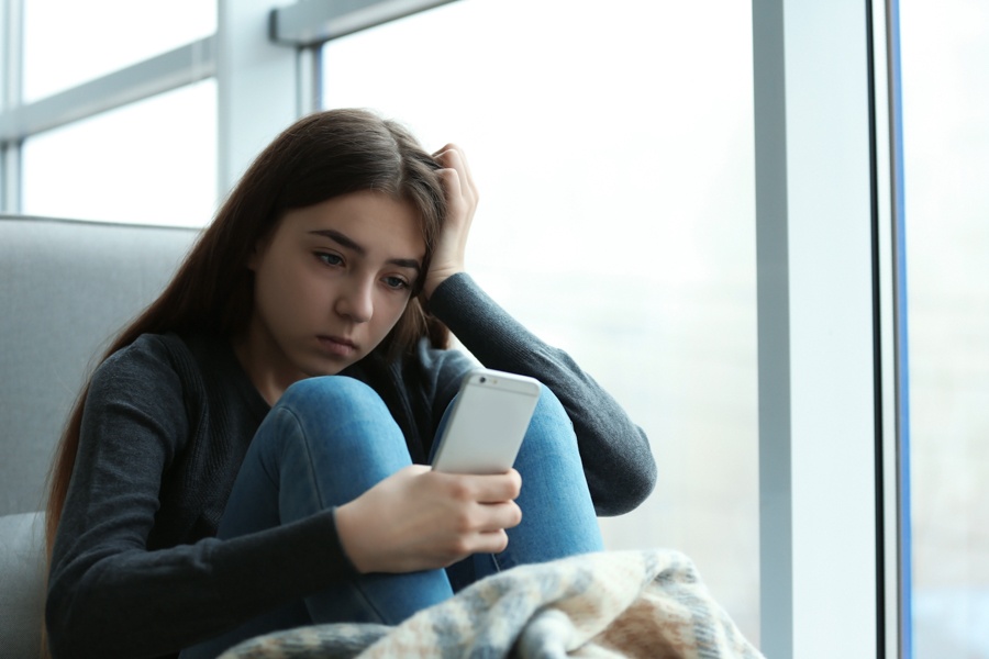 Teen stressed by social media and constant online comparison.