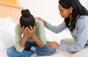 therapist consoles teen girl in thought disorder therapy