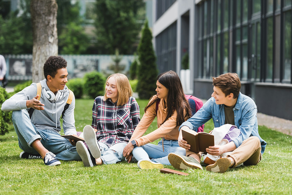 teens sitting outside on the ground together